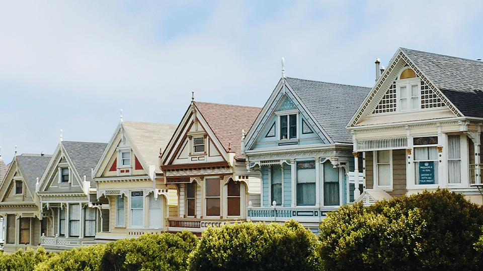 A row of a-framed houses with green bushes in front